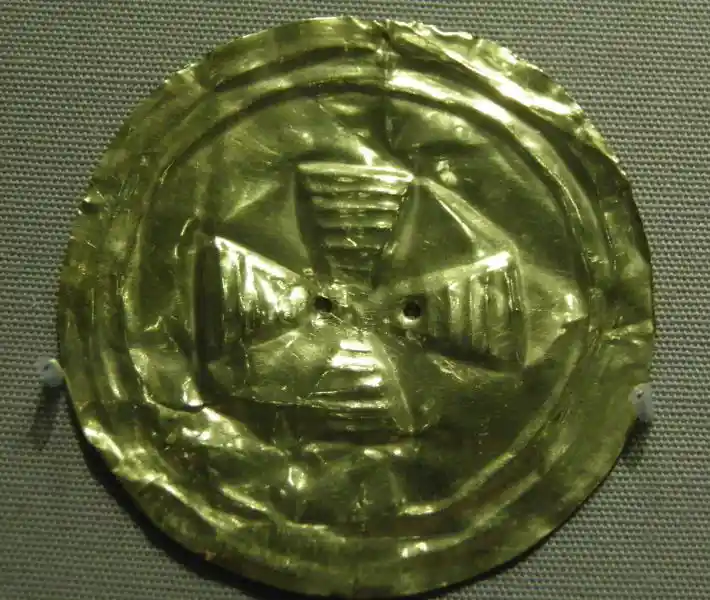 Circular gold disc with a cross in the middle